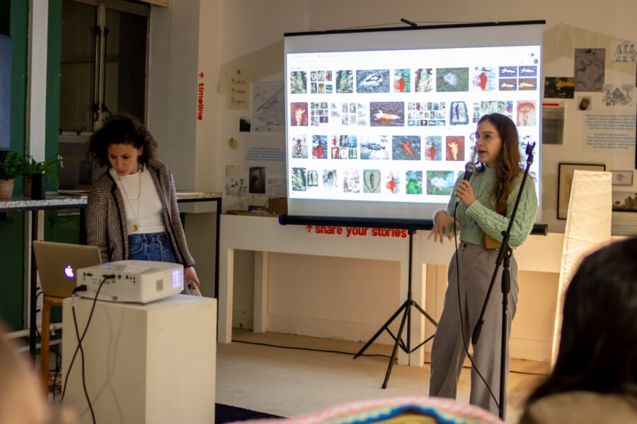 A group doing a presentation with a screen and microphone at St Anne's House.