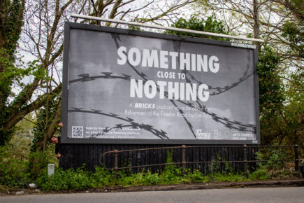 A billboard advertising Something Close To Nothing. A black and white design with a background of barbed wire. White text reading: Something Close To Nothing, A Bricks Podcast Episode about the fishermen of the Feeder Road by Tim Ryan.