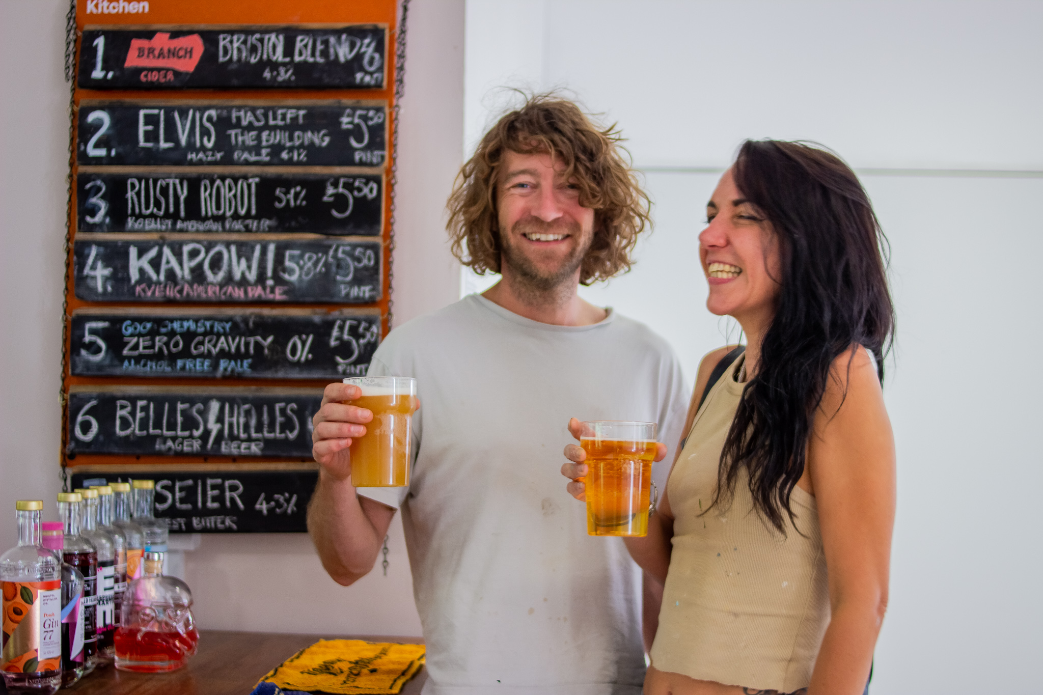 Two people smiling whilst holding beers