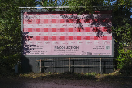 A billboard with shadows cast over. The billboard says 'RE:COLLECTION regathering social practice, a solo show by ellie shipman' and there's hand written words over different coloured pink squares.