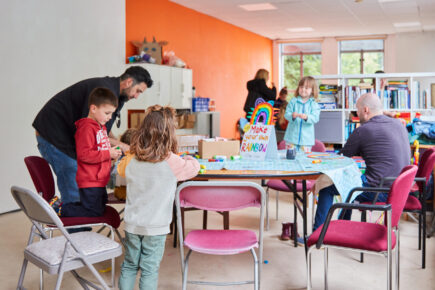 A group of people doing crafts around a table